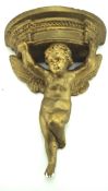A moulded plaster and gilt wall bracket in the form of a winged cherub,