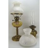 Two brass oil lamps, one with a Hinks lever, the other with a gold coloured glass reservoir,