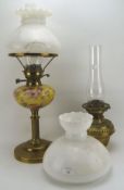 Two brass oil lamps, one with a Hinks lever, the other with a gold coloured glass reservoir,