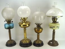 Four19th/20th century oil lamps with glass and brass reserves,