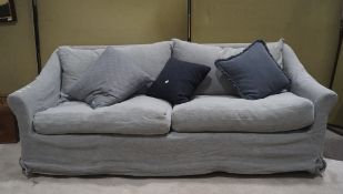 A large pale blue three seater sofa with scatter cushions,