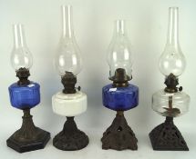 Four Victorian oil lamps with blue, white and colourless glass reserves,