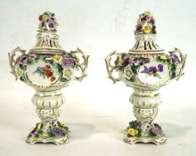 A pair of German porcelain lidded urns, each with twin handles,