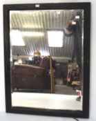 A 20th century black painted bevelled edge wall mirror, of rectangular form,