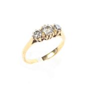 A yellow metal three stone diamond ring, the centre stone measuring 0.