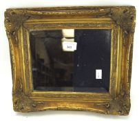 A small bevelled edge mirror in an ornate gilt wood frame,