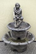 A cast stone water feature, in the form of a child in a contemplative pose,