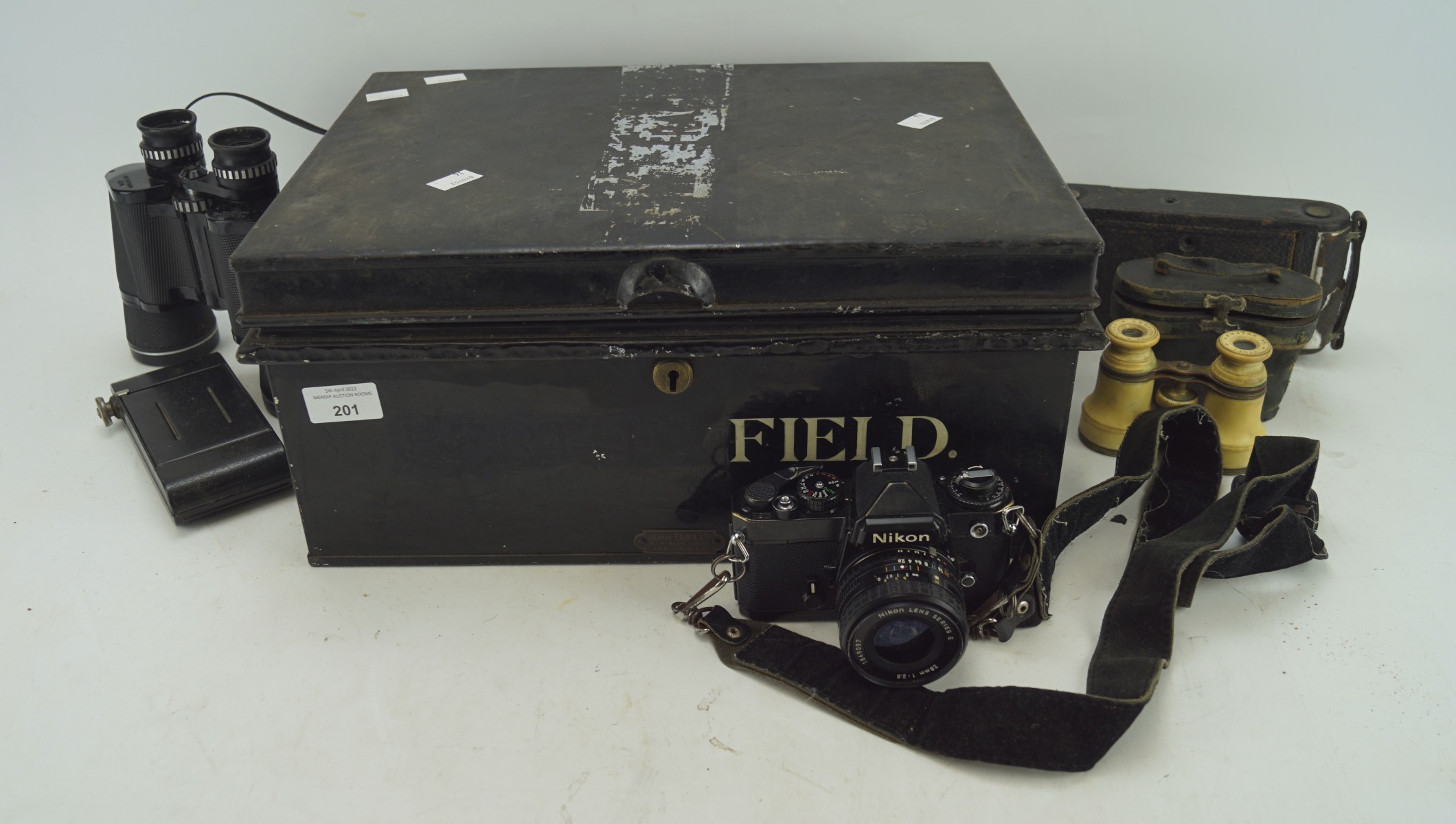 A mid century metal storage box containing a selection of cameras and binoculars,