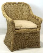 A contemporary Lloyd Loom style wicker chair, with a curved back and cream cushion,