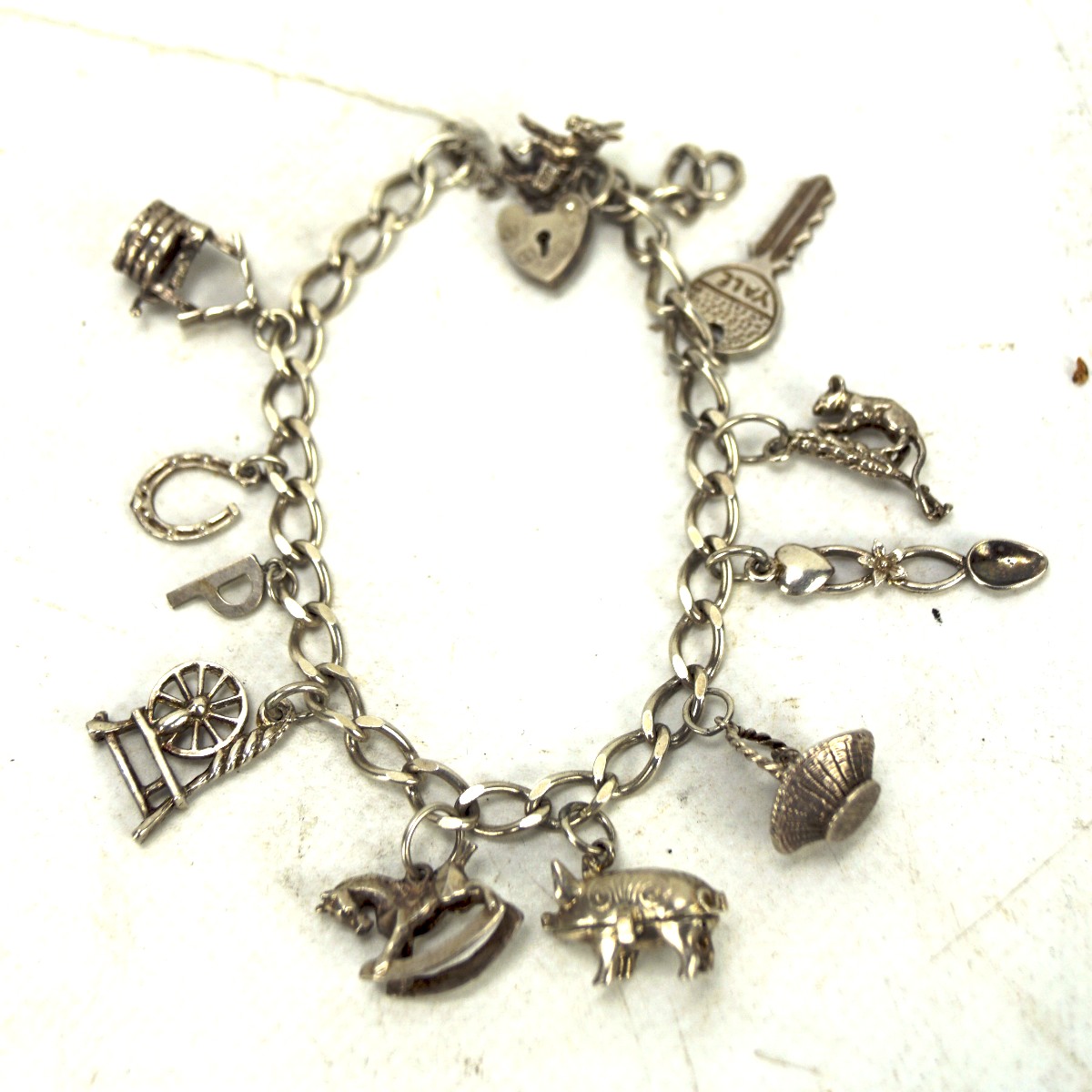 A silver curb link charm bracelet, with an assortment of eight charms, - Image 3 of 3