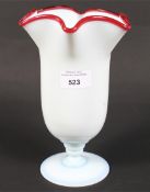 A 20th century opaline glass vase, with red detailing to border, on pedestal base,