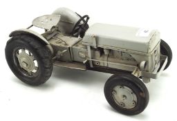 A tinplate model of a tractor, painted in grey,