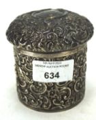 An Edwardian silver lidded pot, of circular form with embossed decoration,