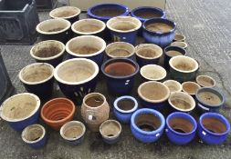 A large collection of glazed plant pots, including numerous blue examples,