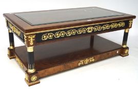 A contemporary coffee table with glass top insert above a drawer, with black and gilt details,