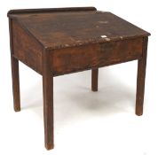 A Victorian stained pine clerks desk, the sloped top with a hinged lid, raised on square supports,