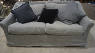A pale blue two-seater sofa with scatter cushions,