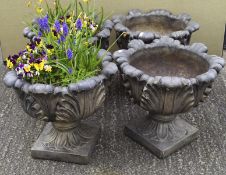 Four cast stone planters, with leaf decoration on a plinth base,