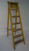 A vintage yellow painted set of step ladders,