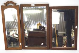 Three wooden framed mirrors, including two bevelled edge examples,