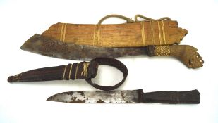 Two tribal knives, one with a leather sheath and handle, the other wooden,