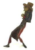 A cast metal figure of a gentleman wearing a hat and carrying a bag, painted,