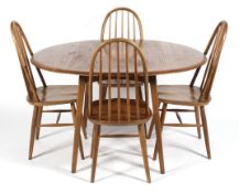 An Ercol blonde elm and beech drop leaf dining table and four hooped spindle back dining chairs,