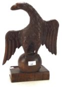 A carved oak model of an eagle, with wings outstretched, on a book-shaped plinth,