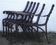 Two pairs of painted iron bench ends, each with wooden arm rests,