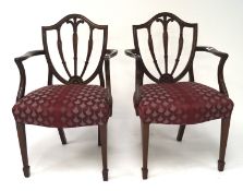 A pair of Georgian style mahogany shield back elbow chairs with a tri-feather motif,