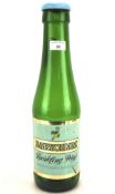 A vintage green glass Babycham bottle, with cap and original label,