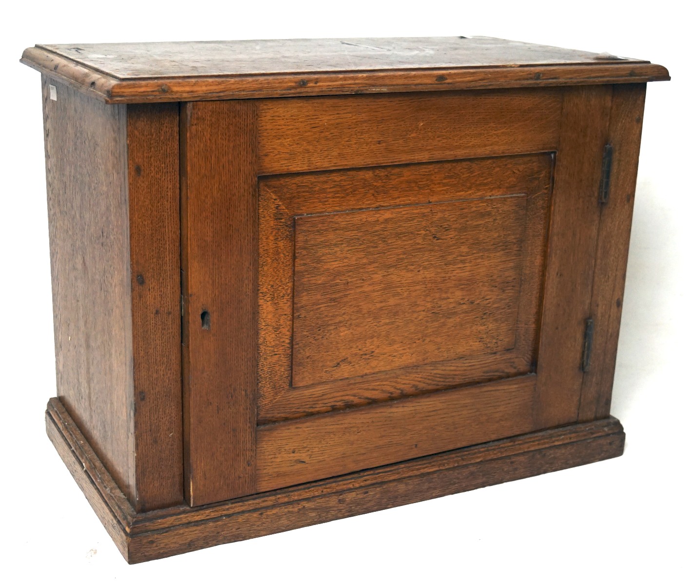A 20th century small oak cabinet, of rectangular form with a bevelled panel to the door,