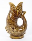 A vintage mustard glazed Dartmouth pottery gluggle jug, in the form of a fish,