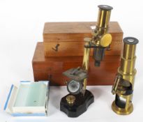 Two antique brass microscopes, within fitted wooden boxes, together with a selection of slides,