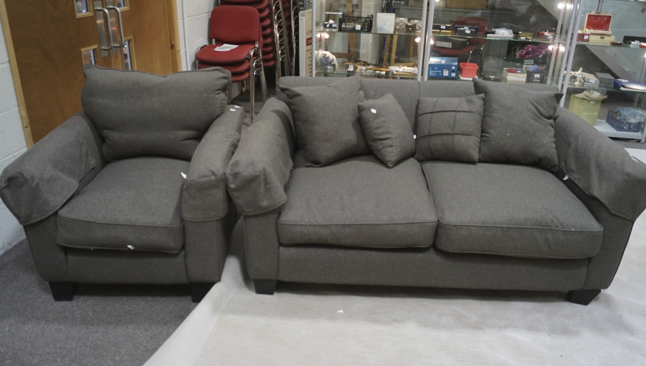 A charcoal two seater sofa and armchar with scatter cushions,