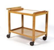 A beech effect two tiered push along tea trolley, with a lift out twin handled glass tray,