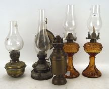 Four late 19th/early 20th century small oil lamps, including a pair of orange glass examples,