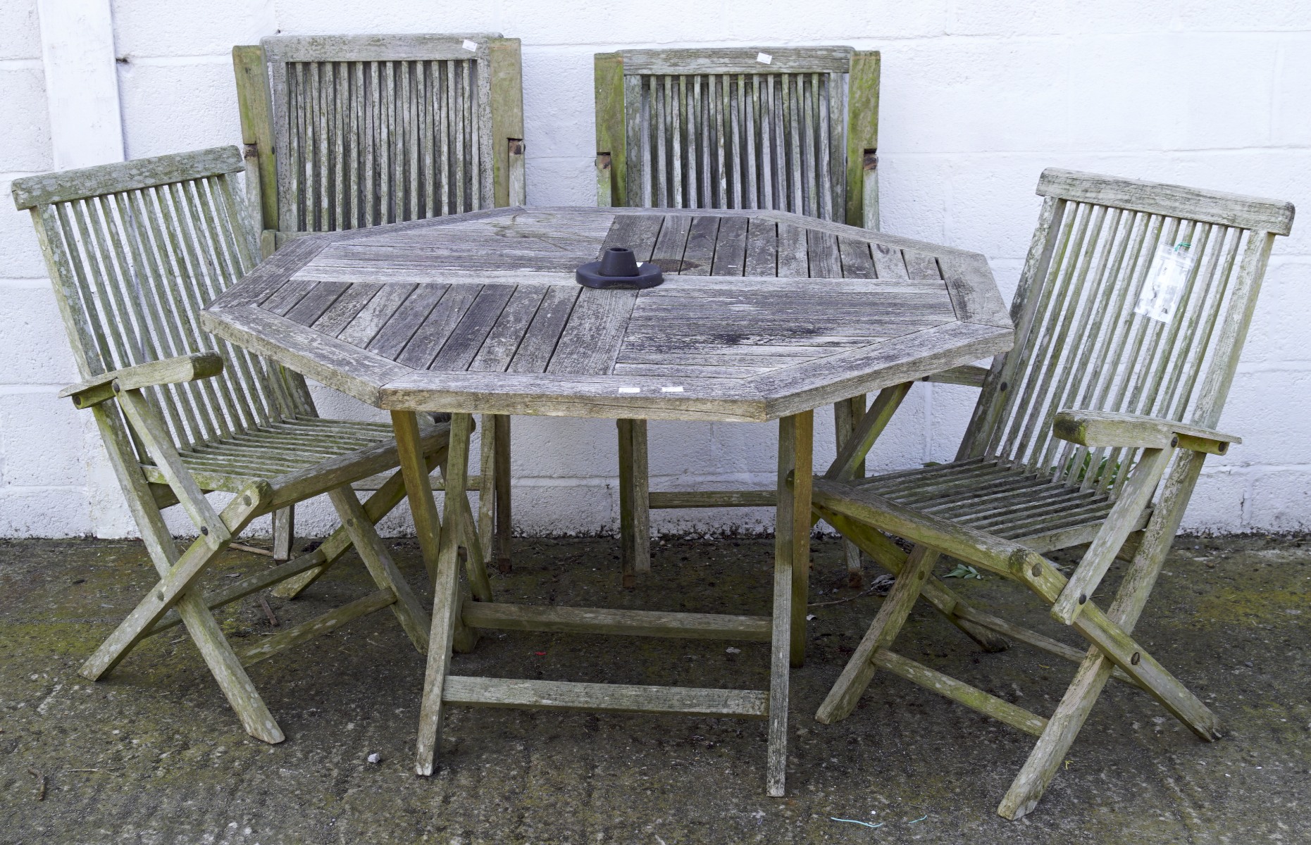 A wooden octagonal slatted section garden table and four chairs, the table measuring 120cm wide,