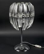 A contemporary glass and chrome table lamp, mounted on a circular base,