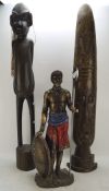 Two carved wooden African tribal sculptures and a similar resin example,