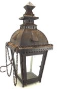 A hanging metal garden lantern, of pagoda form with glazed doors, suspended from chains and hook,