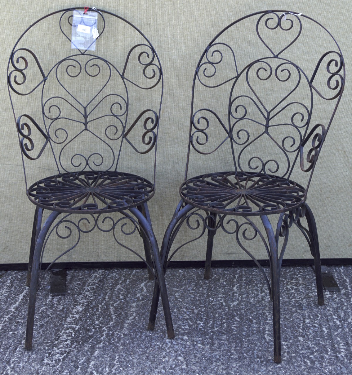 A pair of wrought iron garden chairs, formed from interlocking scrolls, H90.