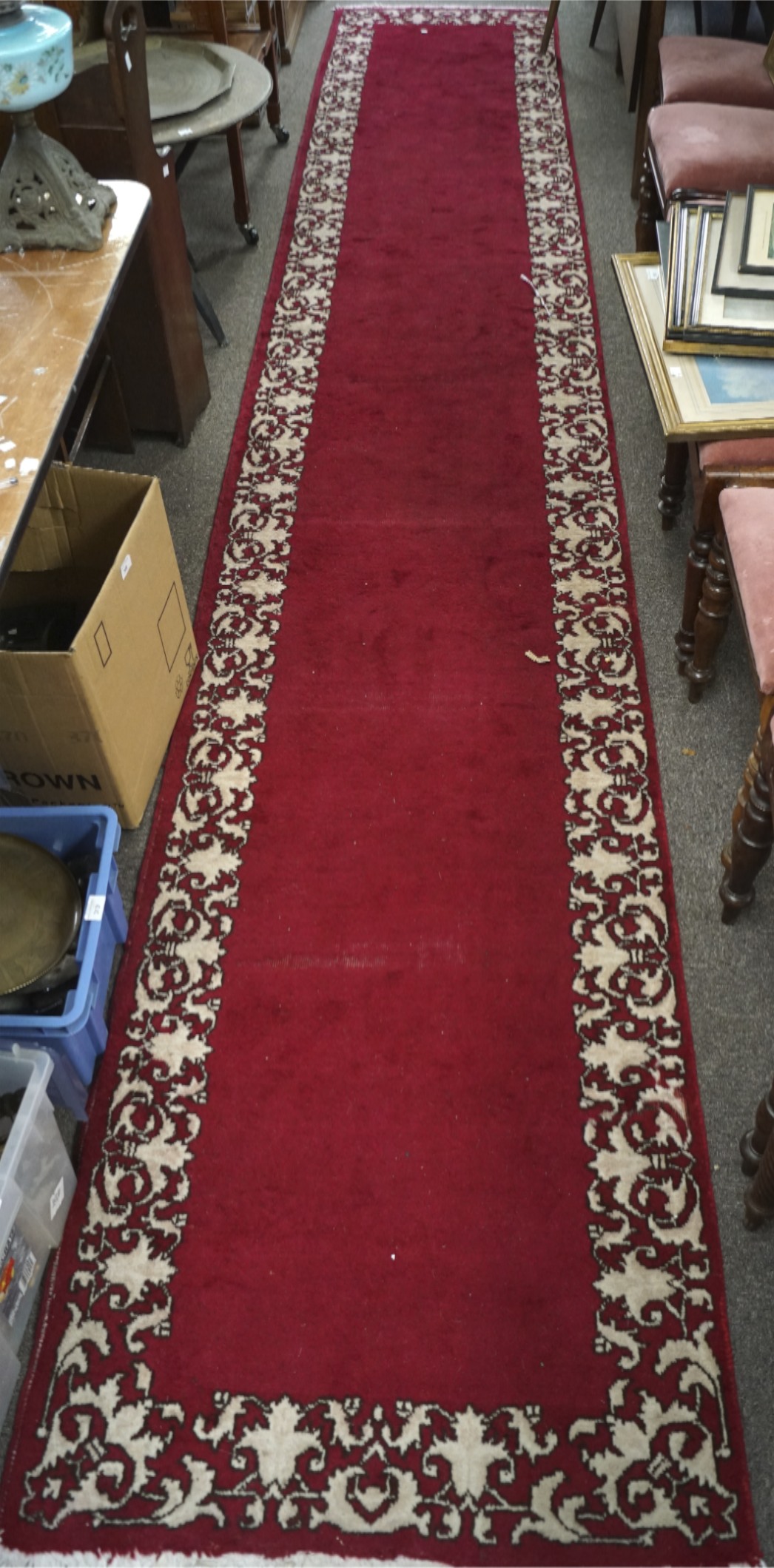 A Tabriz runner, with a cream border on a red ground, tassels to either end,