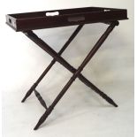 A mahogany butlers tray on folding stand,