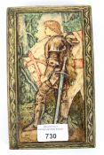 A 20th century painted pottery wall plaque moulded in low relief with a knight and horse,