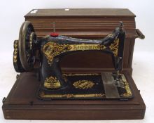 An 1895 Singer sewing machine with gold details, serial number 12603315, with accessories,