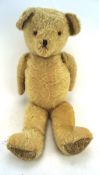 A 1950's jointed straw filled teddy bear,