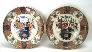 Two late 19th century Japanese Imari plates, each with a jardiniere of flowers,