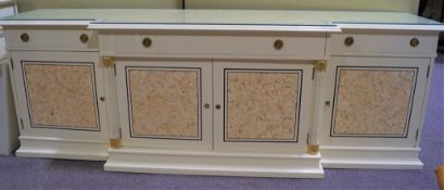 A large cream sideboard of stepped form with two short and one long drawer over cupboards,