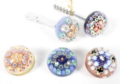 Three contemporary millefiori paperweights and two bottle openers, predominately by Strathearn,